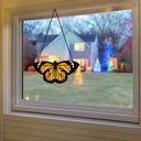 6.5"H Yellow & Orange Butterfly Stained Glass Window Panel hanging in front of a house with Christmas lights
