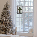 18" H Celtic Cross Stained Glass Window Panel in a large window showing a snowy landscape.
