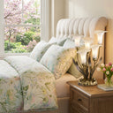 20"H Hand Blown Glass 5 Calla Lily Uplight Accent Lamp in a dedroom with floral bedding and flowers on a nightstand.