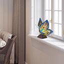 9.5"H Stained Glass Butterfly Wings Accent Lamp on a windowsill with a neutral decor background