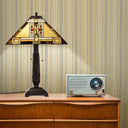 24" H Winslow Tiffany-Style Stained Glass Empire Shade Candlestick Table Lamp, placed on a wooden cabinet next to a retro radio against a striped wallpaper background.