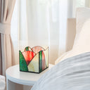 4.75" W Abstract Wave Design Stained Glass Candle Holder on a nightstand next to a bed with white bedding.