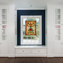24"H Tiffany Style Stained Glass Fiery Hearts and Flowers Window Panel hanging in a window in a room with white cabinets.