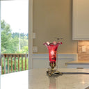 9"H Hand Blown Mercury Glass Lily Uplight Accent Lamp on a table with a view of a balcony and trees outside.