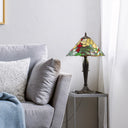 21.5" H Crimson Cardinal Tiffany-Style Stained Glass Cone Shade Candlestick Table Lamp displayed on a gray side table next to a gray sofa in a living room setting.