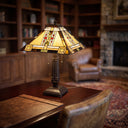 24" H Winslow Tiffany-Style Stained Glass Empire Shade Candlestick Table Lamp, placed on a wooden desk in a cozy, softly blurred study or living room.
