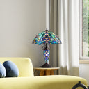 24" H Margaret Double Lit Teal Tiffany Style Stained Glass Table Lamp on a table next to a yellow sofa with blue cushions.